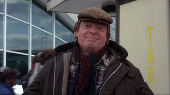 Movie still from “Planes, Trains & Automobiles” (1987), directed by John Hughes – A person wearing a hat and scarf; Close Up shot, Over the shoulder angle