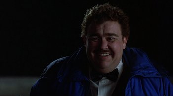 Movie still from “Planes, Trains & Automobiles” (1987), directed by John Hughes – A person wearing a jacket and a bow tie; Close Up shot, Low angle