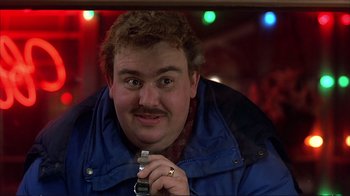 Movie still from “Planes, Trains & Automobiles” (1987), directed by John Hughes – A person holding a cell phone; Close Up shot, Over the shoulder angle