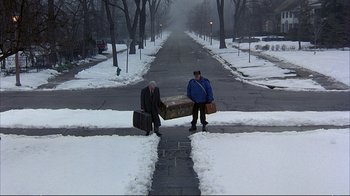 Movie still from “Planes, Trains & Automobiles” (1987), directed by John Hughes – Two men with suitcases on the side of the road; Wide shot, High angle
