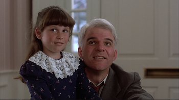 Movie still from “Planes, Trains & Automobiles” (1987), directed by John Hughes – A man and a little girl sitting next to each other; Close Up shot, Over the shoulder angle