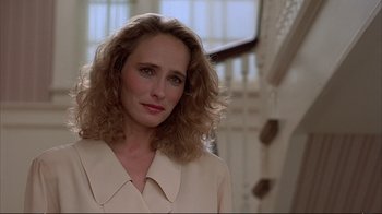 Movie still from “Planes, Trains & Automobiles” (1987), directed by John Hughes – A person with curly hair wearing a suit; Close Up shot, Over the shoulder angle