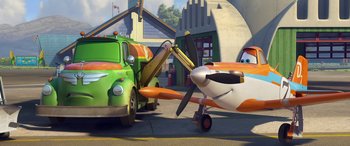 Movie still from “Planes: Fire & Rescue” (2014), directed by Bobs Gannaway – An animated plane and a truck in front of a building; Wide shot, Low angle