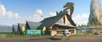 Movie still from “Planes: Fire & Rescue” (2014), directed by Bobs Gannaway – An airplane is flying in front of a building; Extreme Wide shot, Low angle