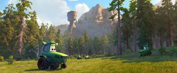 Movie still from “Planes: Fire & Rescue” (2014), directed by Bobs Gannaway – A group of people standing in the grass near a mountain; Extreme Wide shot, Low angle