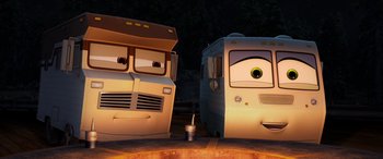 Movie still from “Planes: Fire & Rescue” (2014), directed by Bobs Gannaway – Two cartoon buses are parked next to each other on the street; Wide shot, Low angle