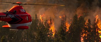 Movie still from “Planes: Fire & Rescue” (2014), directed by Bobs Gannaway – A helicopter is flying over a forest fire; Extreme Wide shot, Low angle