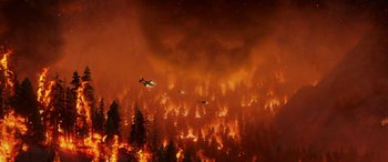 Movie still from “Planes: Fire & Rescue” (2014), directed by Bobs Gannaway – Two planes are flying over a forest on fire; Extreme Wide shot, High angle
