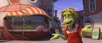 Movie still from “Planet 51” (2009), directed by Javier Abad – A woman in a red shirt is standing in front of a train; Medium shot, Low angle