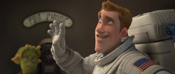 Movie still from “Planet 51” (2009), directed by Javier Abad – A man in a white suit is waving to the camera; Medium shot, Low angle