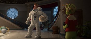 Movie still from “Planet 51” (2009), directed by Javier Abad – A man in a spacesuit is holding something in his hand; Wide shot, Low angle