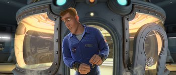 Movie still from “Planet 51” (2009), directed by Javier Abad – An animated man in a blue jacket is holding a remote control; Medium shot, Over the shoulder angle