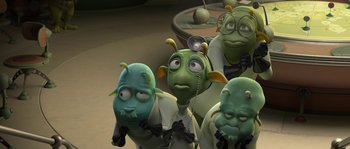 Movie still from “Planet 51” (2009), directed by Javier Abad – A group of people with green heads and a white shirt; Medium shot, High angle