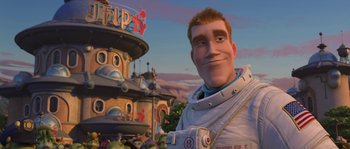 Movie still from “Planet 51” (2009), directed by Javier Abad – An animated man in front of a building; Medium shot, Over the shoulder angle