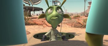 Movie still from “Planet 51” (2009), directed by Javier Abad – An animated creature is sitting in the sand; Medium shot, High angle