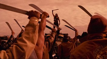 Movie still from “Planet Terror” (2007), directed by Robert Rodriguez – A group of people holding up swords in the air; Wide shot, Low angle