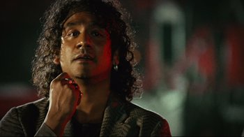 Movie still from “Planet Terror” (2007), directed by Robert Rodriguez – A man with long curly black hair is looking at the camera; Close Up shot, Low angle