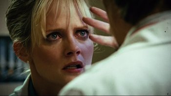 Movie still from “Planet Terror” (2007), directed by Robert Rodriguez – A woman looking in the mirror with her hand on her forehead; Close Up shot, Low angle