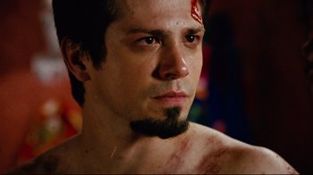 Movie still from “Planet Terror” (2007), directed by Robert Rodriguez – A person with a scar on his face; Close Up shot, Low angle