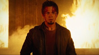 Movie still from “Planet Terror” (2007), directed by Robert Rodriguez – A man in a brown leather jacket and a fire background; Close Up shot, Low angle