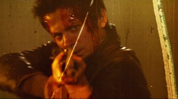Movie still from “Planet Terror” (2007), directed by Robert Rodriguez – A man holding a knife in his hand; Close Up shot, Low angle