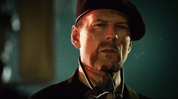 Movie still from “Planet Terror” (2007), directed by Robert Rodriguez – A person wearing a hat and a tie; Close Up shot, Low angle