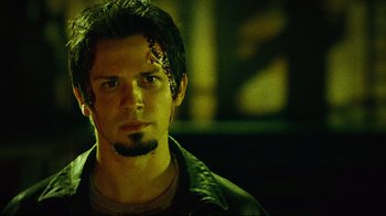 Movie still from “Planet Terror” (2007), directed by Robert Rodriguez – A person wearing a black jacket; Close Up shot, Low angle