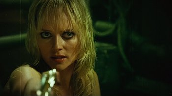 Movie still from “Planet Terror” (2007), directed by Robert Rodriguez – A woman with blonde hair holding a gun in her hand; Close Up shot, Low angle