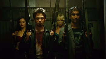Movie still from “Planet Terror” (2007), directed by Robert Rodriguez – A group of people standing next to each other holding knives; Medium shot, Low angle