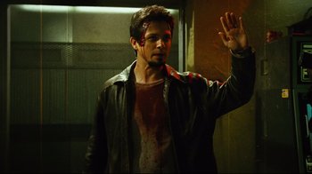 Movie still from “Planet Terror” (2007), directed by Robert Rodriguez – A man in a leather jacket with blood all over his face; Medium shot, High angle
