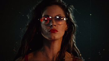 Movie still from “Planet Terror” (2007), directed by Robert Rodriguez – A woman with long hair wearing a pair of glasses; Close Up shot, Low angle