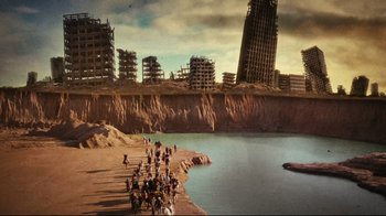 Movie still from “Planet Terror” (2007), directed by Robert Rodriguez – A group of people standing on top of a sandy beach; Extreme Wide shot, High angle