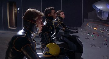 Movie still from “Planet of the Vampires” (1965), directed by Mario Bava – A group of men in black and yellow suits; Medium shot, Low angle
