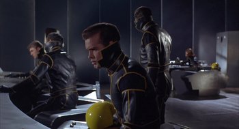 Movie still from “Planet of the Vampires” (1965), directed by Mario Bava – A group of people in black and yellow suits; Medium shot, Low angle