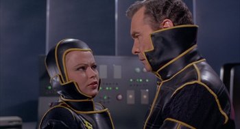 Movie still from “Planet of the Vampires” (1965), directed by Mario Bava – A man and a woman in black and yellow costumes; Medium shot, Low angle