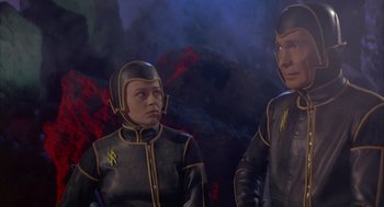 Movie still from “Planet of the Vampires” (1965), directed by Mario Bava – A couple of people in black and yellow suits; Medium shot, High angle