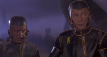 Movie still from “Planet of the Vampires” (1965), directed by Mario Bava – A couple of people that are in some kind of costume; Medium shot, High angle