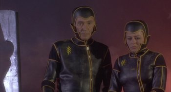 Movie still from “Planet of the Vampires” (1965), directed by Mario Bava – A man and a woman in black and yellow costumes; Medium shot, High angle