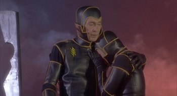 Movie still from “Planet of the Vampires” (1965), directed by Mario Bava – A man in a black and yellow suit is posing for a picture; Medium shot, Low angle