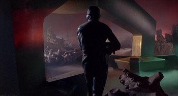 Movie still from “Planet of the Vampires” (1965), directed by Mario Bava – A man standing in front of an image of a city; Wide shot, Low angle