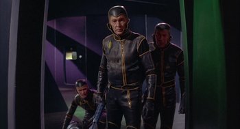 Movie still from “Planet of the Vampires” (1965), directed by Mario Bava – A group of people in black and yellow suits; Medium shot, Low angle