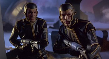 Movie still from “Planet of the Vampires” (1965), directed by Mario Bava – Two men in black and yellow suits holding guns; Medium shot, Low angle