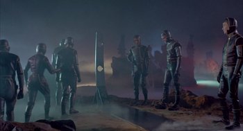 Movie still from “Planet of the Vampires” (1965), directed by Mario Bava – A group of men standing next to each other in a field; Wide shot, High angle