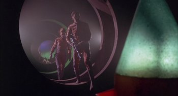 Movie still from “Planet of the Vampires” (1965), directed by Mario Bava – A man and a woman are standing in the dark; Wide shot, Low angle
