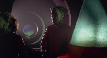 Movie still from “Planet of the Vampires” (1965), directed by Mario Bava – A man standing in a dark room with a light in the background; Medium shot, Low angle