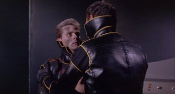 Movie still from “Planet of the Vampires” (1965), directed by Mario Bava – A man in a leather jacket looking at another man in a leather jacket; Close Up shot, Over the shoulder angle