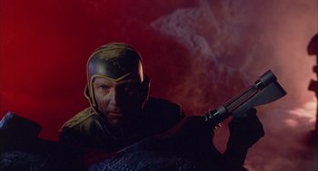 Movie still from “Planet of the Vampires” (1965), directed by Mario Bava – A man with a helmet on and a gun in his hand; Medium shot, Low angle