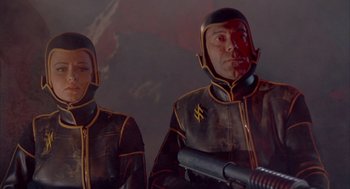 Movie still from “Planet of the Vampires” (1965), directed by Mario Bava – A man and a woman dressed in black and yellow; Medium shot, Low angle