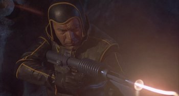 Movie still from “Planet of the Vampires” (1965), directed by Mario Bava – A man with a gun in a dark room; Medium shot, High angle