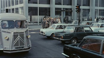 Movie still from “Playtime” (1967), directed by Jacques Tati – A group of people standing on the side of a road; Extreme Wide shot, High angle